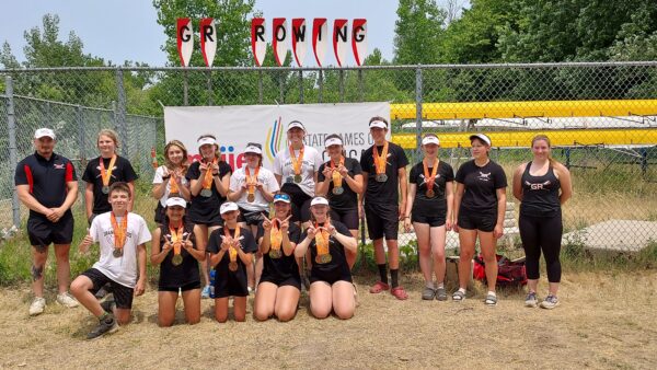 Grand Rapids Junior Rowing team posing with medals from a regatta